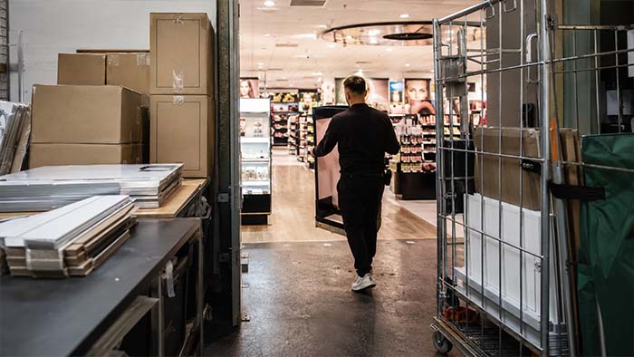 Materiales y expositor de PLV trasladados desde el almacén a la zona de venta durante la ejecución de una campaña retail.